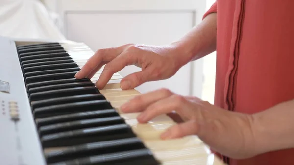 Músico a tocar sintetizador. o músico toca piano. mãos femininas jogar o sintetizador . — Fotografia de Stock