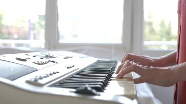 Músico a tocar sintetizador. o músico toca piano. mãos femininas jogar o sintetizador . — Fotografia de Stock