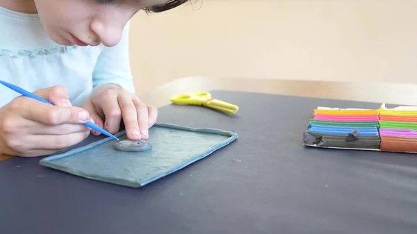坐在桌边的女孩从颜色模型橡皮泥中抽取不同的数字。儿童艺术造型的发展。特写, — 图库照片