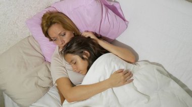 Anne ve çocukları yatakta yatan konuşuyor. kopya alanı