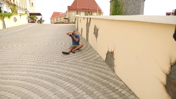 Fotógrafo masculino está tirando fotos na rua com a ajuda de uma câmera profissional. espaço de cópia — Fotografia de Stock