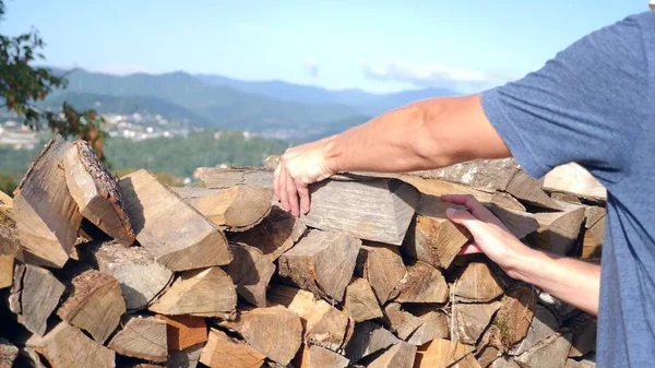 Madeira, pilha de madeira para um inverno gelado, para acender uma lareira em um chalé. contra o fundo das montanhas . — Fotografia de Stock