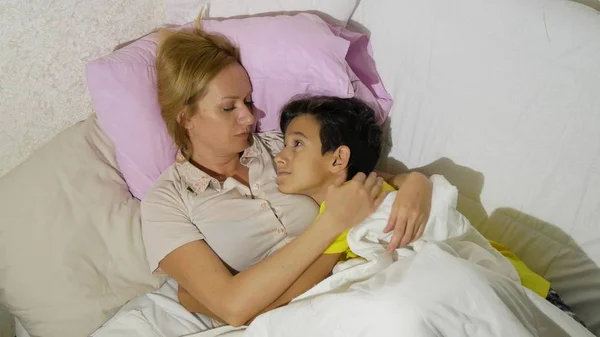 Mother and her children talking lying in bed. copy space — Stock Photo, Image