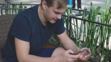 bir büyük alışveriş bir kafede karmaşık otururken bir adam onun banka kartı ve telefon kullanır