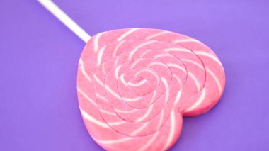 Bir kalp şeklinde renkli sarmal lolipop.