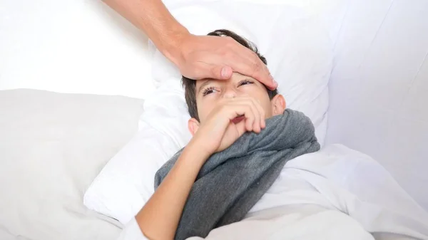 En sjuk pojke låg i sängen med feber. kopia utrymme — Stockfoto