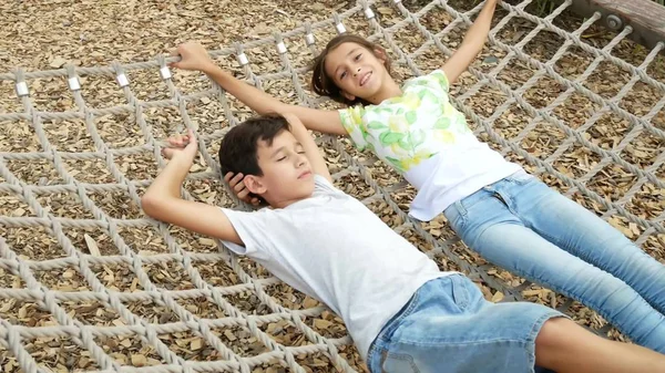 Pair of happy children boy and girl on hammock. copy space — Stock Photo, Image