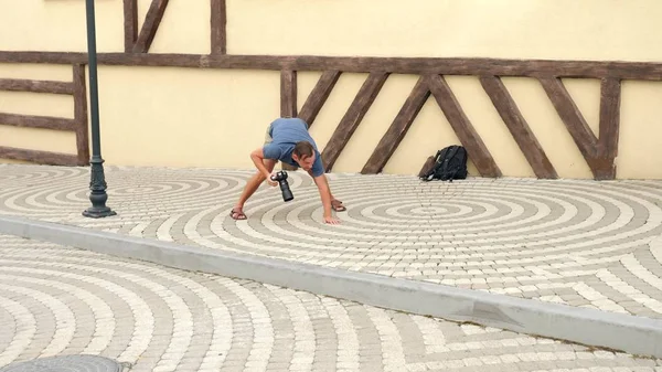 Fotógrafo masculino está tirando fotos na rua com a ajuda de uma câmera profissional. espaço de cópia — Fotografia de Stock