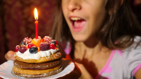 День рождения маленькой девочки она задувает свечи на торте . — стоковое фото