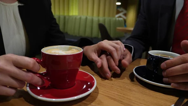 Közelkép, kezében egy férfi és egy nő, egy kávézóban. ők csendesen megsimogatta egymás kezét. — Stock Fotó