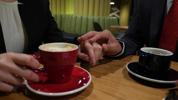 Gros plan, les mains d'un homme et d'une femme dans un café. ils se caressèrent silencieusement les mains . — Photo