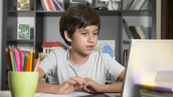 Begreppet lärande online. barnet är inskriven i en online-skola. pojken gör läxor med laptop. — Stockfoto