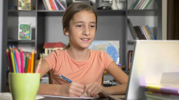 Concept d'apprentissage en ligne. l'enfant est inscrit dans une école en ligne. fille faire des devoirs avec ordinateur portable . — Photo