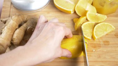 Eller düşük narenciye zencefil kökü ile el yapımı yapılan bir içki için bir bıçak-limon ile kesmek