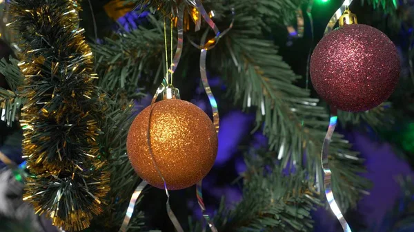 Een ingerichte en verlichte kerstboom, een mooie sprankelende bal met veelkleurige wazig lichten van een slinger. — Stockfoto