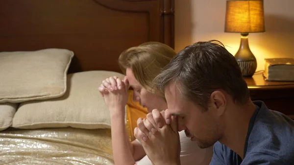 A man and a woman, a married couple praying before going to bed — Stock Photo, Image