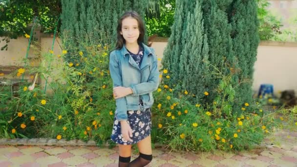 Portrait of beautiful young girl walking outdoors in autumn. She poses for the camera — Stock Video