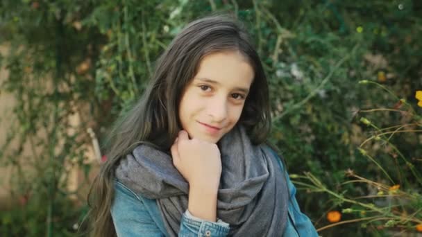 Портрет красивої молодої дівчини, що виходить на вулицю восени. Вона позує на камеру — стокове відео