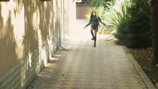 Una joven saltando sobre una cuerda saltando en el patio trasero. Otoño — Vídeos de Stock