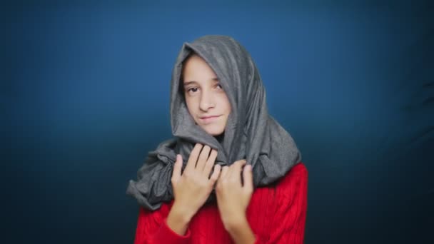 Beautiful teen girl in autumn clothes , posing at camera over blue background — Stock Video