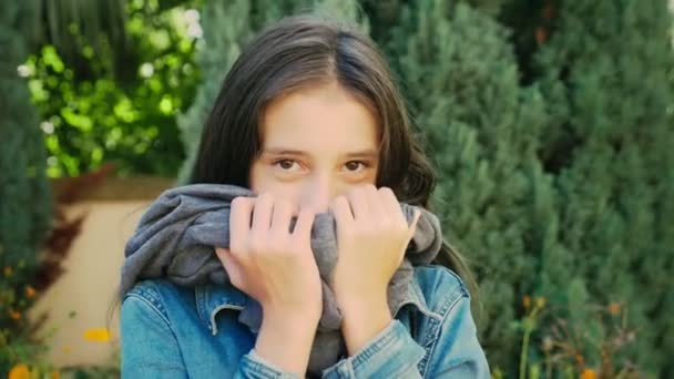 Retrato de menina bonita andando ao ar livre no outono. Ela posa para a câmera — Vídeo de Stock