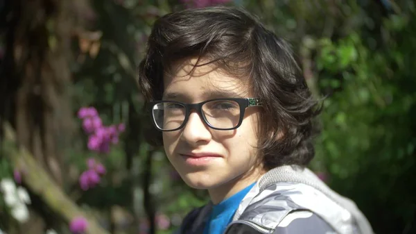 Podobizna chlapce nosí brýle, při pohledu na fotoaparát v letním parku — Stock fotografie