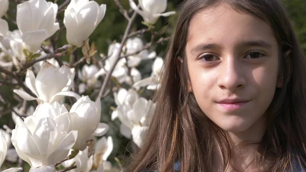 庭に白いモクレンの花背景に美しい十代の少女。太陽のまぶしさ — ストック写真