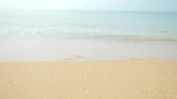 Γυναικεία πόδια στην άμμο, το κύμα της θάλασσας καλύπτει τα γυναικεία πόδια — Φωτογραφία Αρχείου