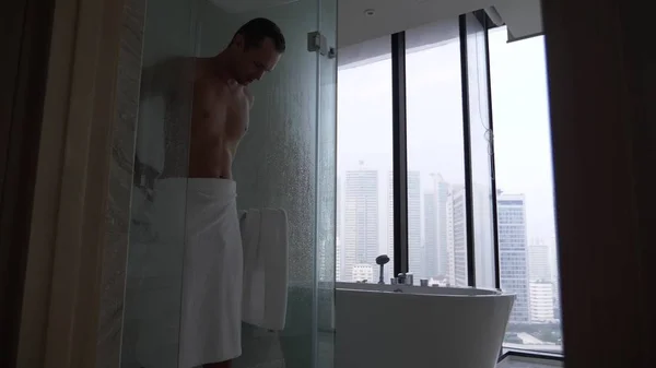 浴室で若い男は。ハンサムな男はシャワーを浴びた後、タオルで拭いてください。 — ストック写真