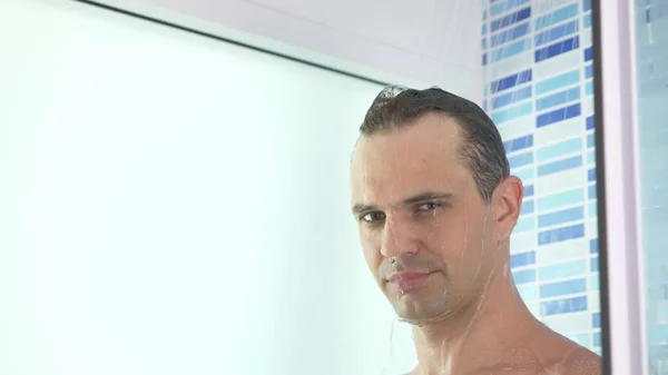 Schöner junger Mann nimmt eine Dusche. Kopierraum — Stockfoto