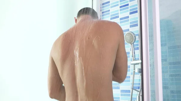 Schöner junger Mann nimmt eine Dusche. Kopierraum — Stockfoto
