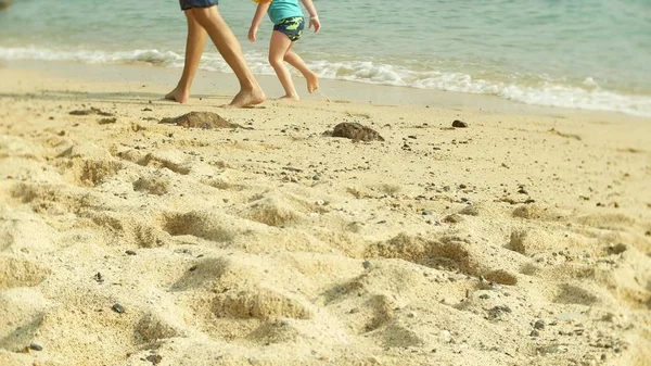 Pés descalços de um menino e seu pai que descansam em uma praia tropical . — Fotografia de Stock