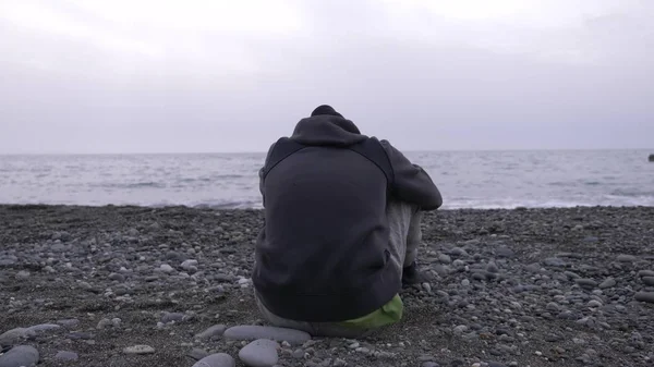 A magányos fiú ül a strandon. — Stock Fotó