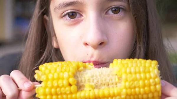 面白い少女ティーンエイ ジャーゆでたトウモロコシを食べるします。クローズ アップ. — ストック写真