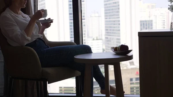 美丽的女人喝咖啡的窗口俯瞰城市 摩天大楼 — 图库照片