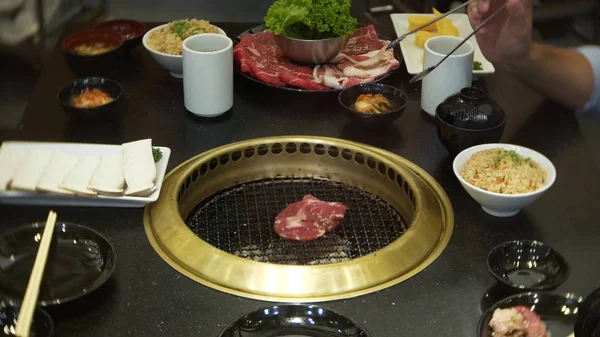 Φαγητό σε bulgogi, κορεάτες μπάρμπεκιου, στο εστιατόριο. μαγείρεμα κινέζικο εστιατόριο στον πίνακα κάρβουνα μπάρμπεκιου, γκρο πλαν — Φωτογραφία Αρχείου