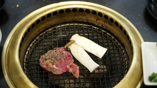 Comida em bulgogi, churrasco coreano, no restaurante. cozinhar no restaurante chinês na mesa grelhar churrasco, close-up — Fotografia de Stock