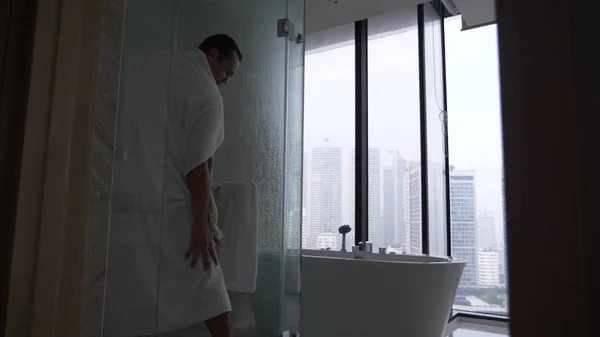 Jeune homme dans la salle de bain. un beau mec est essuyé par une serviette après une douche . — Photo