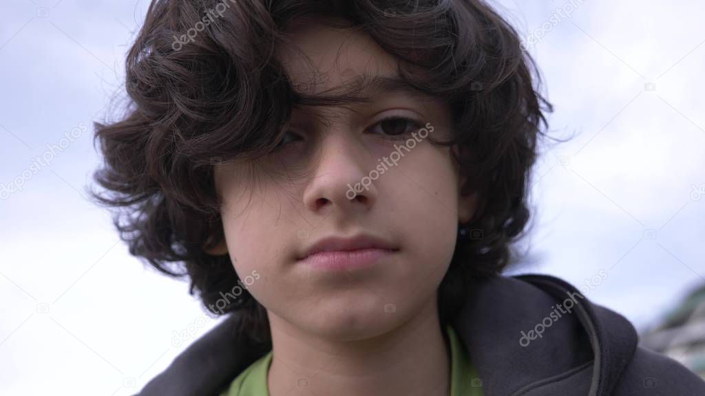 Cute teenager with curly hair against the blue sky