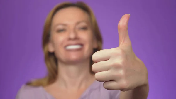 Glad ung kvinna visar ok tecken med fingrarna och blinka. bakgrundsfärg — Stockfoto