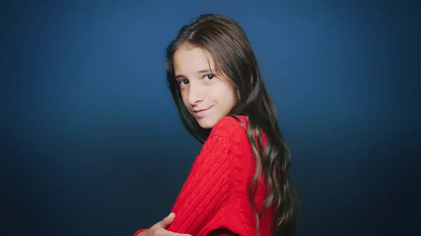 Красивая девушка-подросток в осенней одежде, позирует перед камерой на синем фоне — стоковое фото