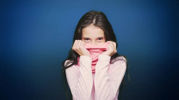 Schönes Teenie-Mädchen in Herbstkleidung posiert vor der Kamera vor blauem Hintergrund — Stockfoto