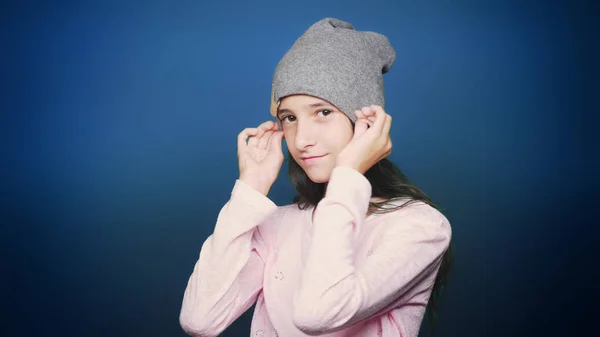 Szép tini lány őszi ruhákat, pózol a kamera felső kék háttér — Stock Fotó