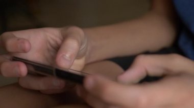 Çocuk el cep telefonu ekran bir oyun oynarken dokunmadan. yakın çekim. Çocukluk ve modern teknoloji kavramı.
