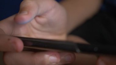Çocuk el cep telefonu ekran bir oyun oynarken dokunmadan. yakın çekim. Çocukluk ve modern teknoloji kavramı.