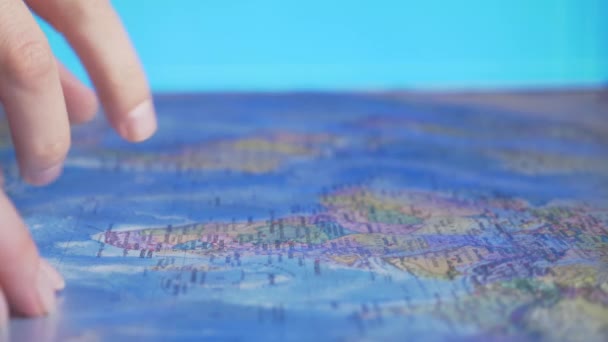 Wahl des Reiselandes. wo man Urlaub machen kann. Hand auf dem Hintergrund der Weltkarte — Stockvideo
