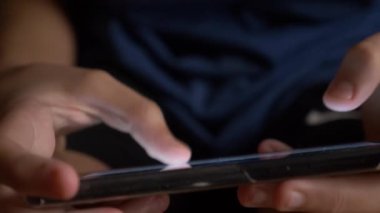 Çocuk el cep telefonu ekran bir oyun oynarken dokunmadan. yakın çekim. Çocukluk ve modern teknoloji kavramı.