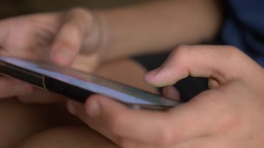 Çocuk el cep telefonu ekran bir oyun oynarken dokunmadan. yakın çekim. Çocukluk ve modern teknoloji kavramı.