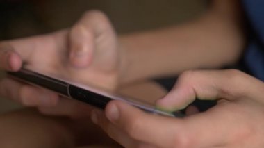 Çocuk el cep telefonu ekran bir oyun oynarken dokunmadan. yakın çekim. Çocukluk ve modern teknoloji kavramı.