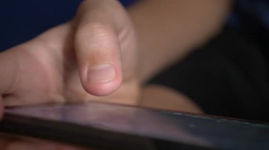 Çocuk el cep telefonu ekran bir oyun oynarken dokunmadan. yakın çekim. Çocukluk ve modern teknoloji kavramı.